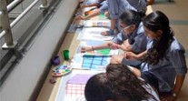 Des élèves de l'école Voltaire du Caire peignent sur des photographies d'immeubles pendant une APP sur le développement durable 
