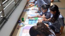 Des élèves de l'école Voltaire du Caire peignent sur des photographies d'immeubles pendant une APP sur le développement durable 